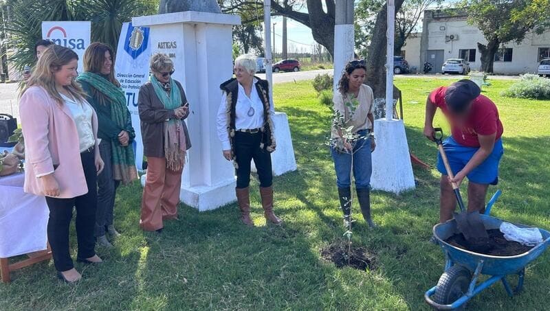 Autoridades y jóven plantando un árbol